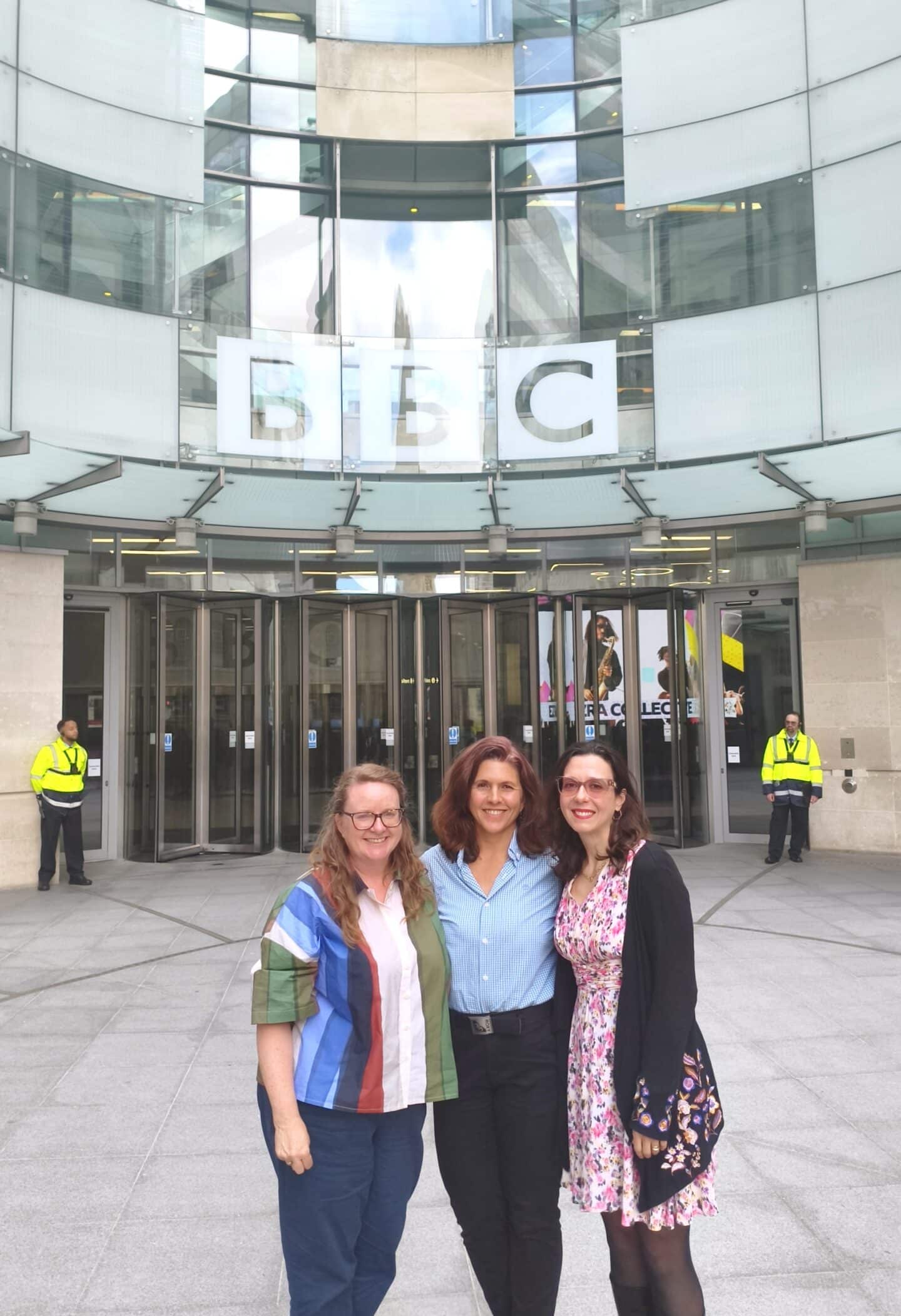 Thre women standing outside the BBC headquarters in London.