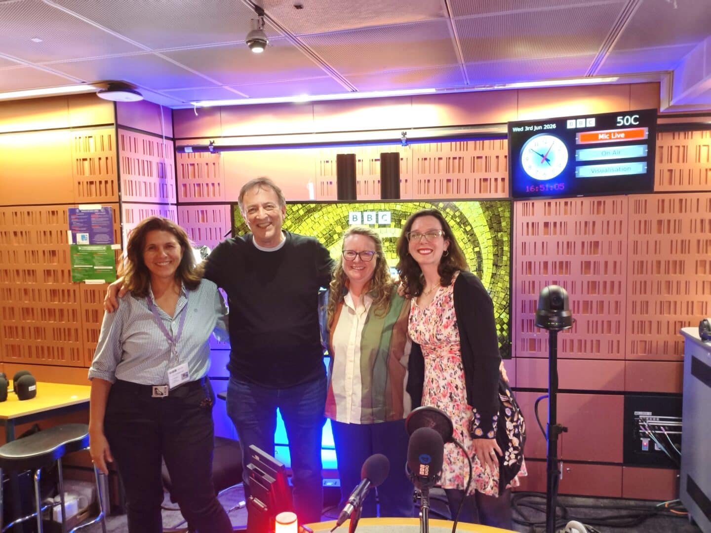 four adults standing in a recording studio