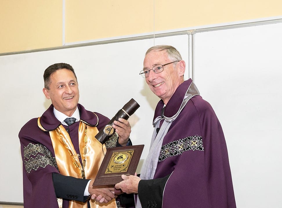 Mark Moloney and receiving his a plaque and scroll and shaking hands with a colleague