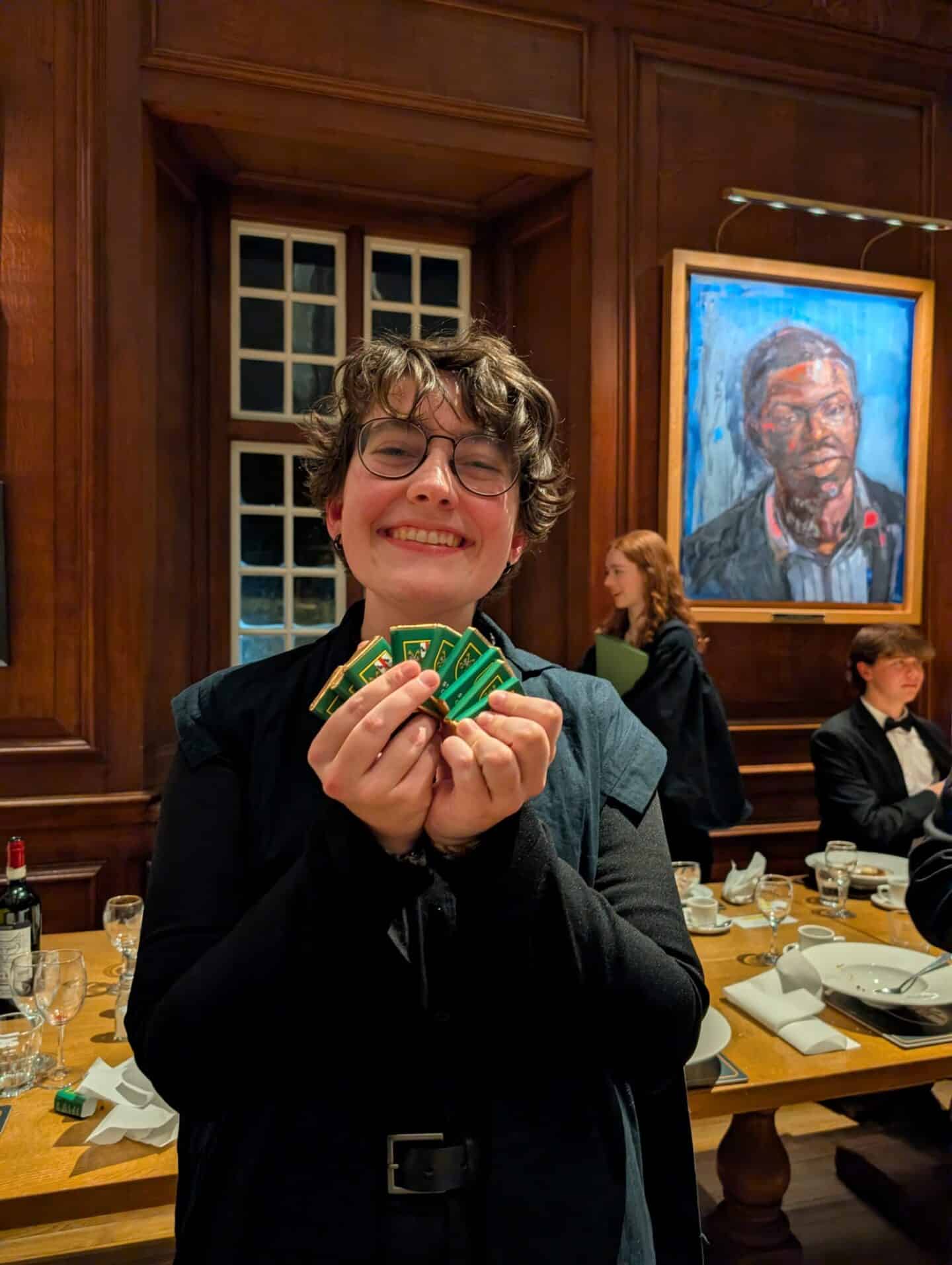 A smiling student holding St Peter's branded chocolates