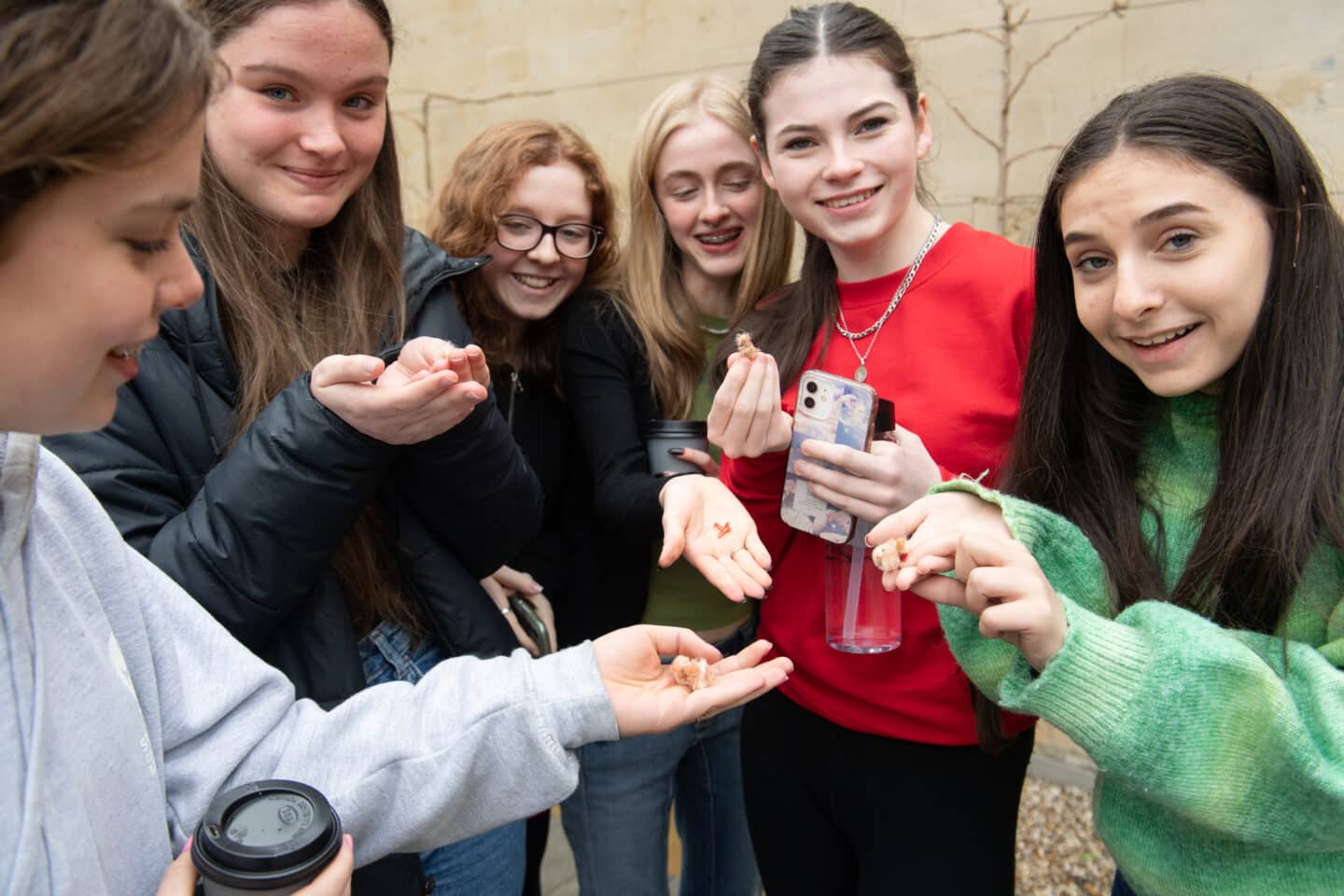 A group of students holding small toy chickens