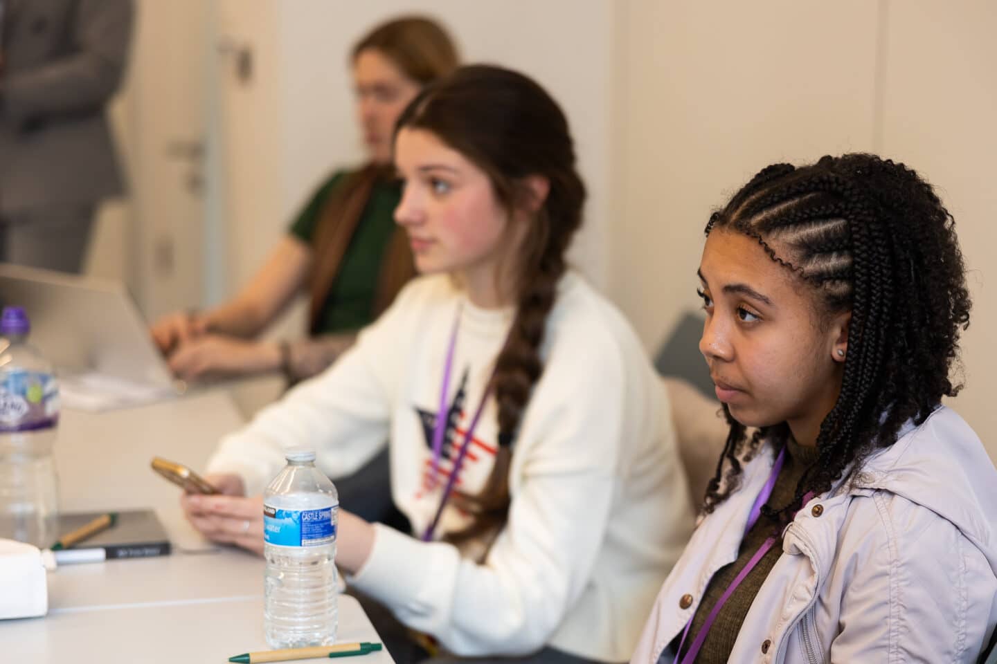 Three young people sat in a room with a table