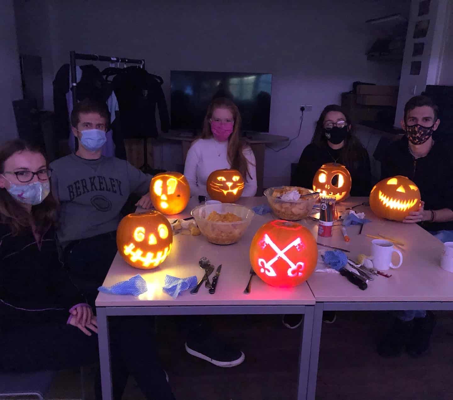 five students with lighted jack-o-lanterns