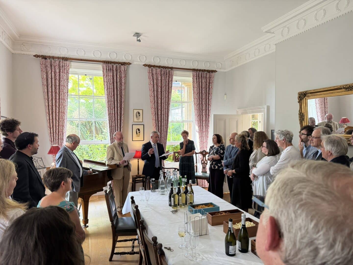 A group of people standing and listening to a man give a speech