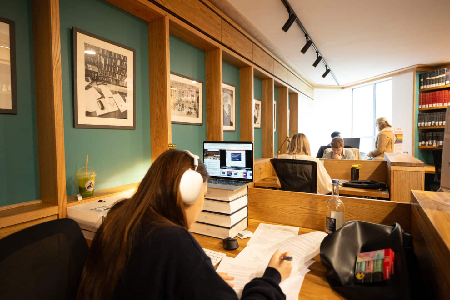 Students in the St Peter's College library study area with desks and book displays