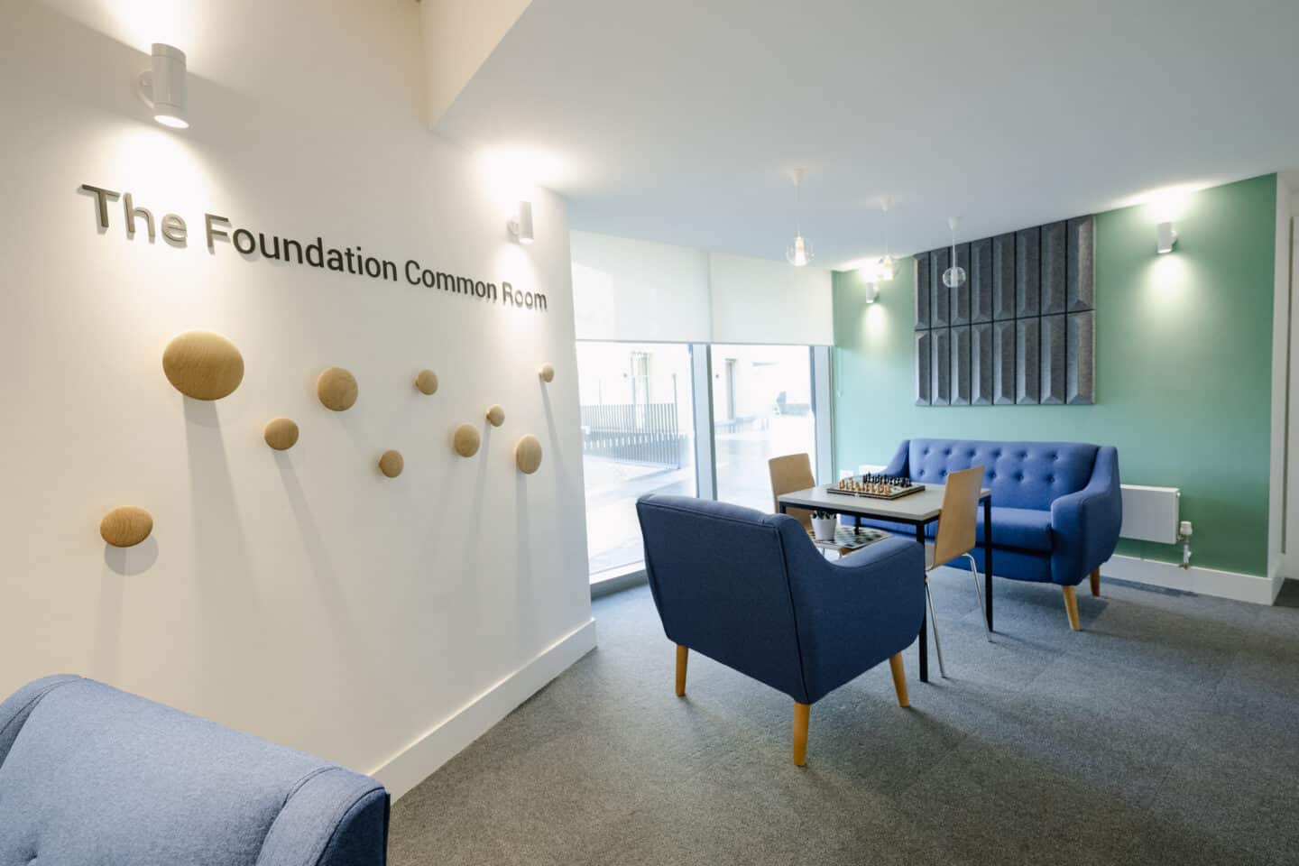 A common room with soft furnishings, tables and chairs