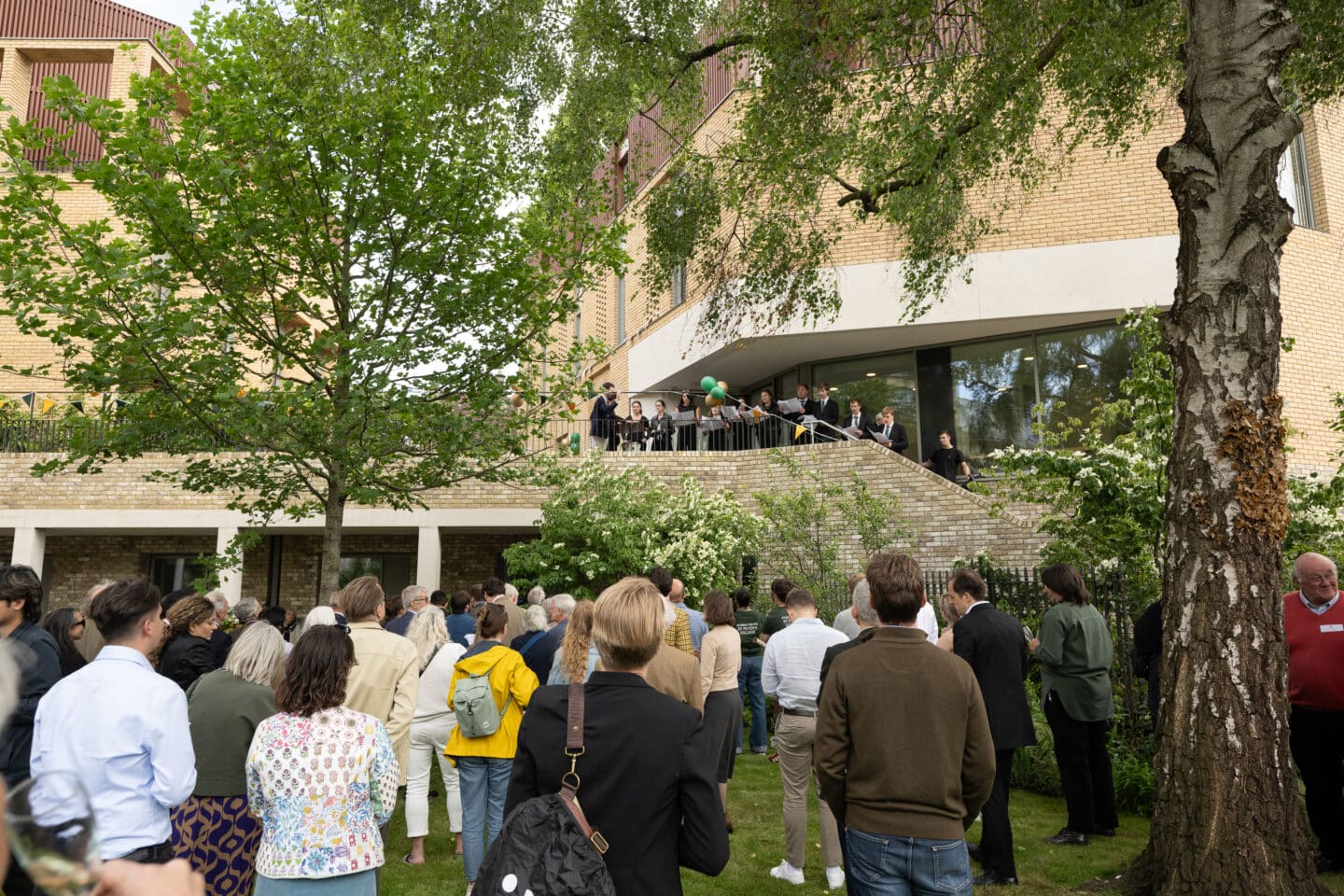 A crowd watching a small choir sing from a raised platform