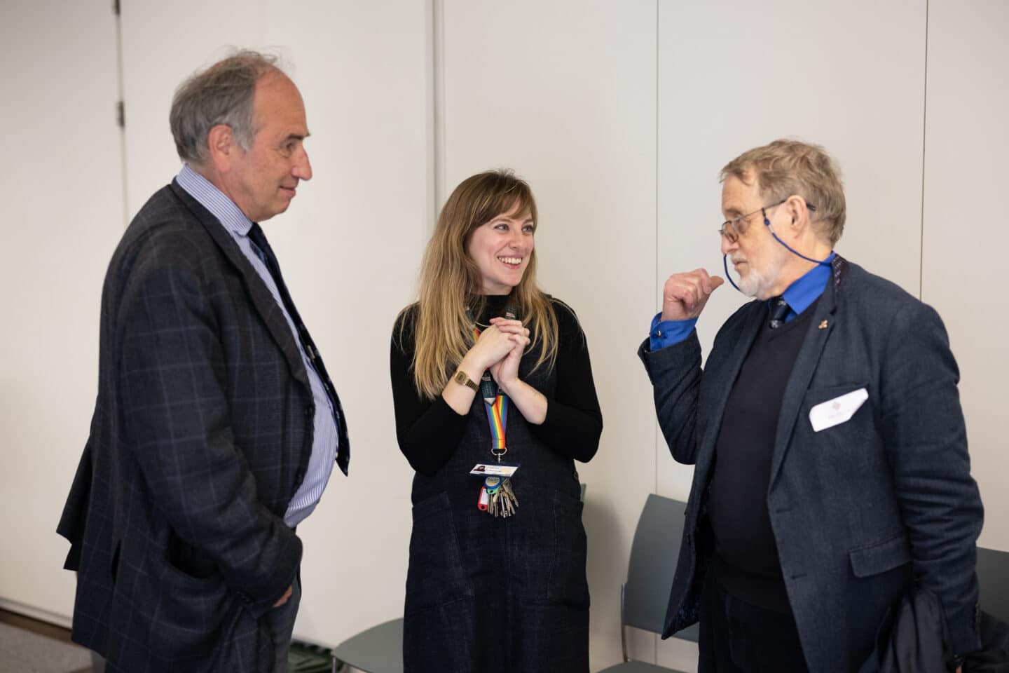 Three adults speaking together indoors