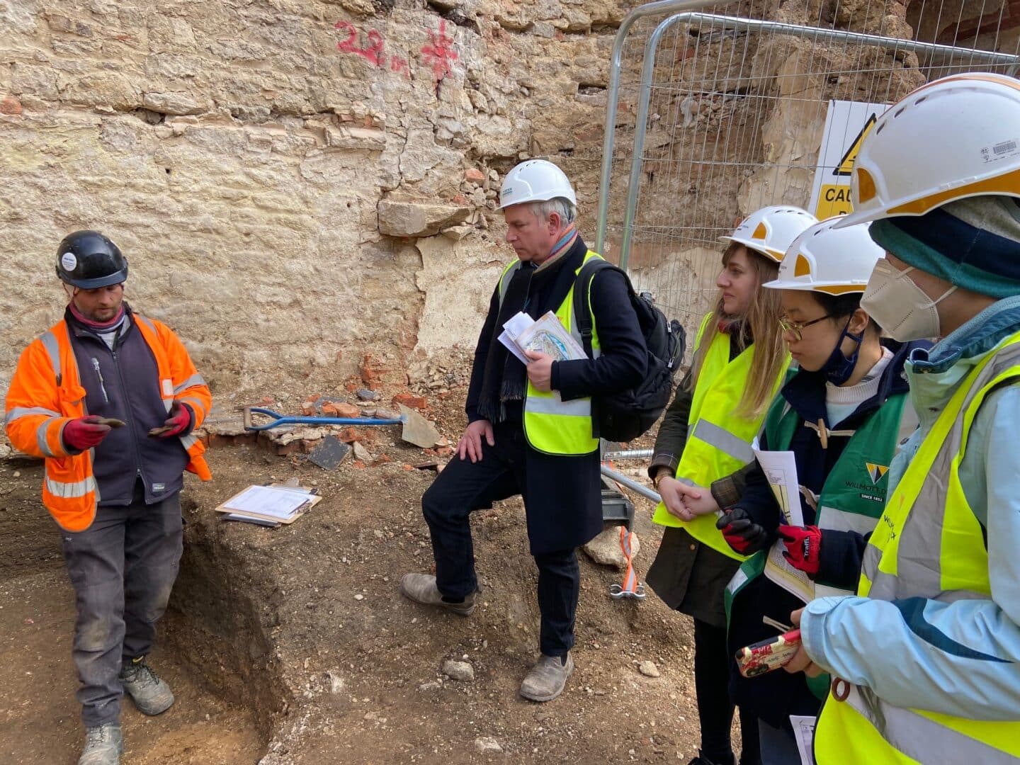 A group of people in hard hats at an archaeological site