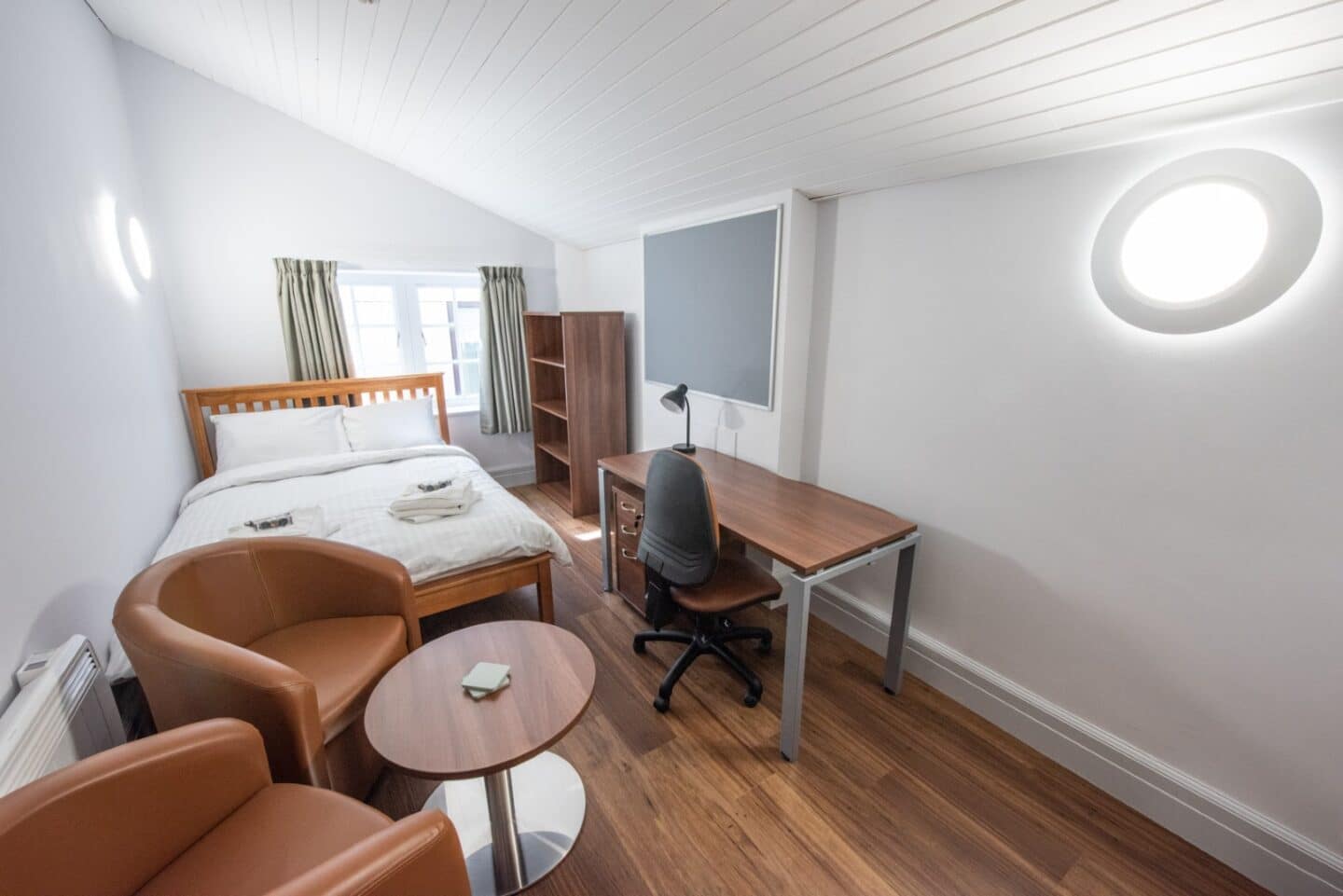 Room with bed, desk and coffee table and chairs