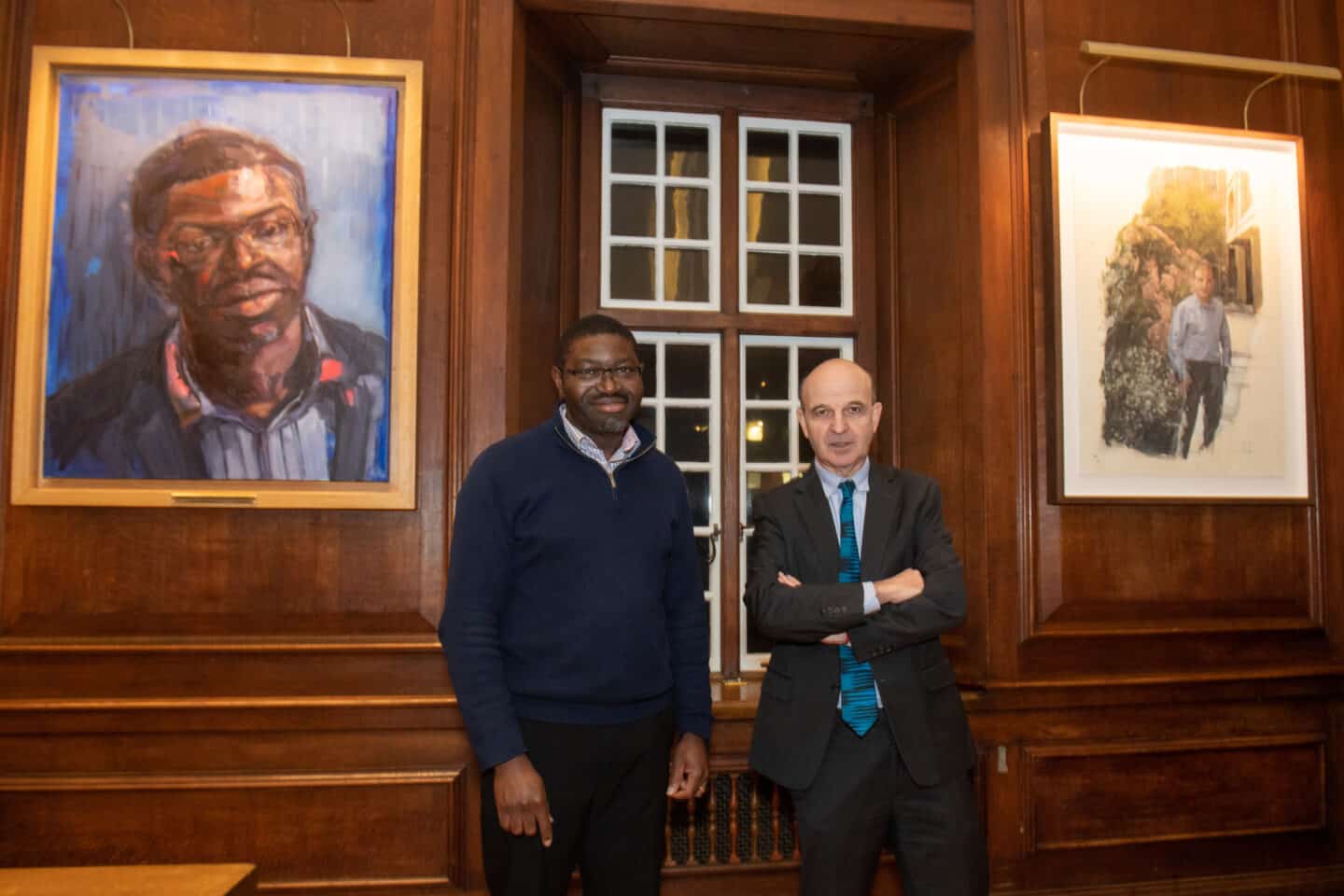 Professor Dapo Akande and Mark Damazer in front of their portraits