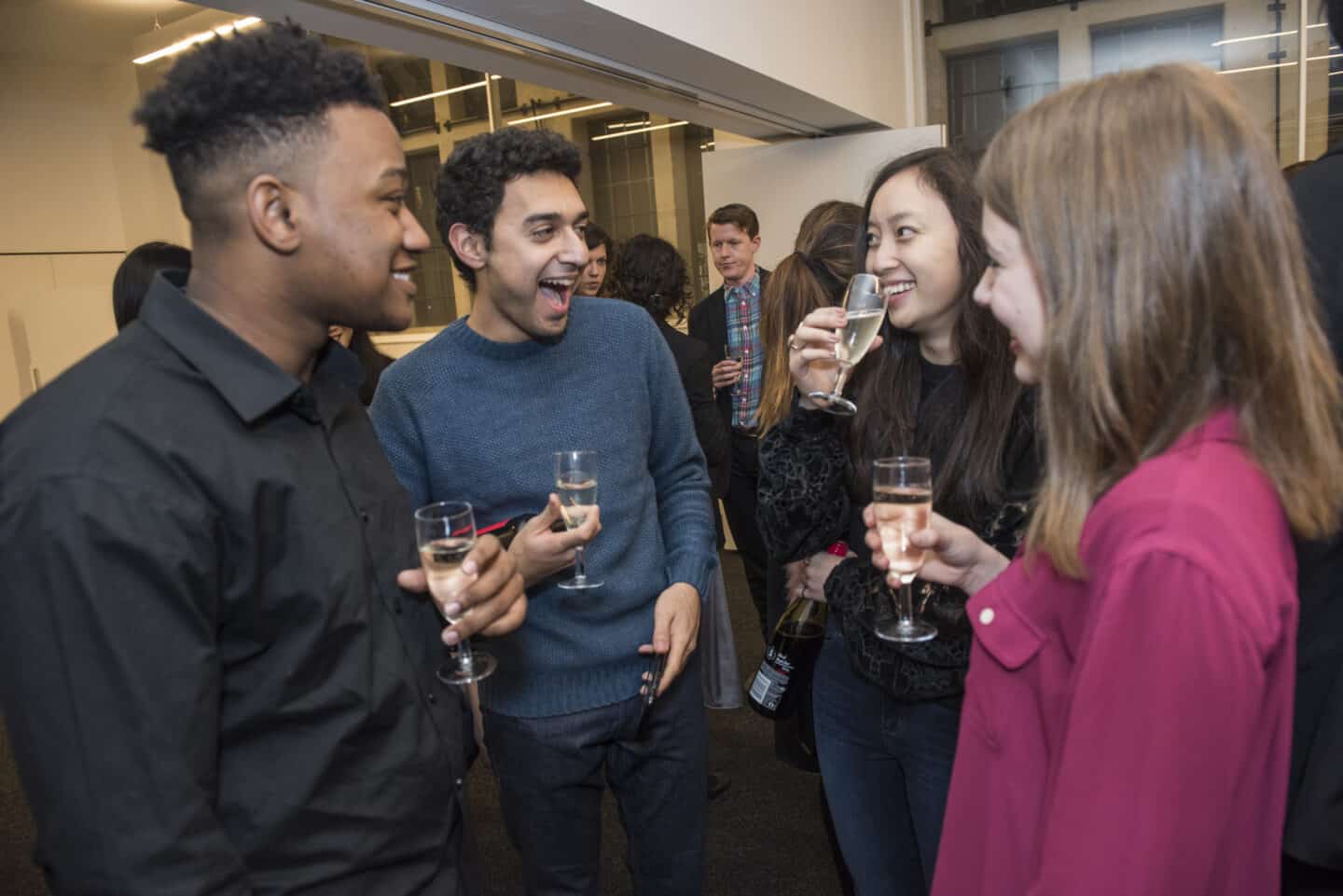 four people smiling and drinking champagne