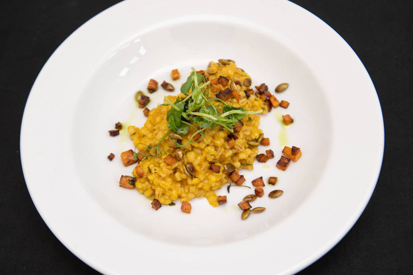 A plated dinner showing vegan risotto with butternut squash