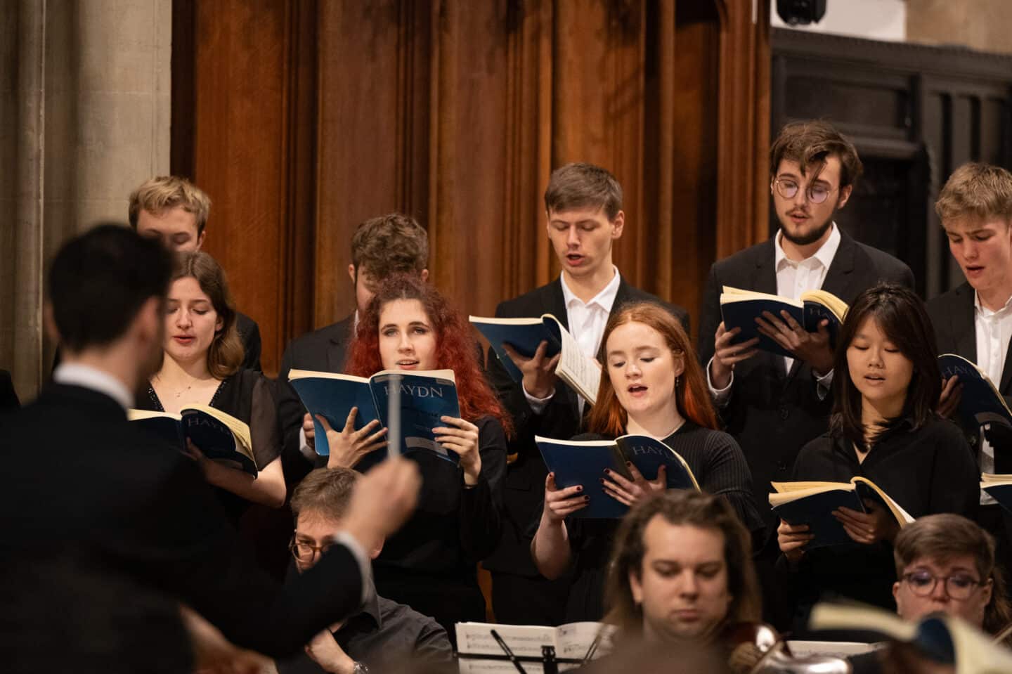 A choir of young people singing and holding the sheet music for a Haydn mass