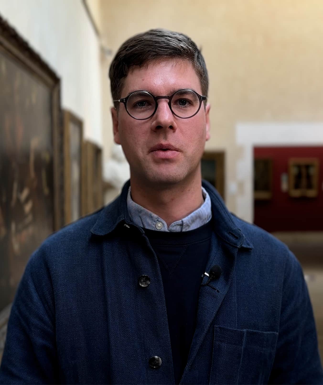A headshot of a man wearing glasses