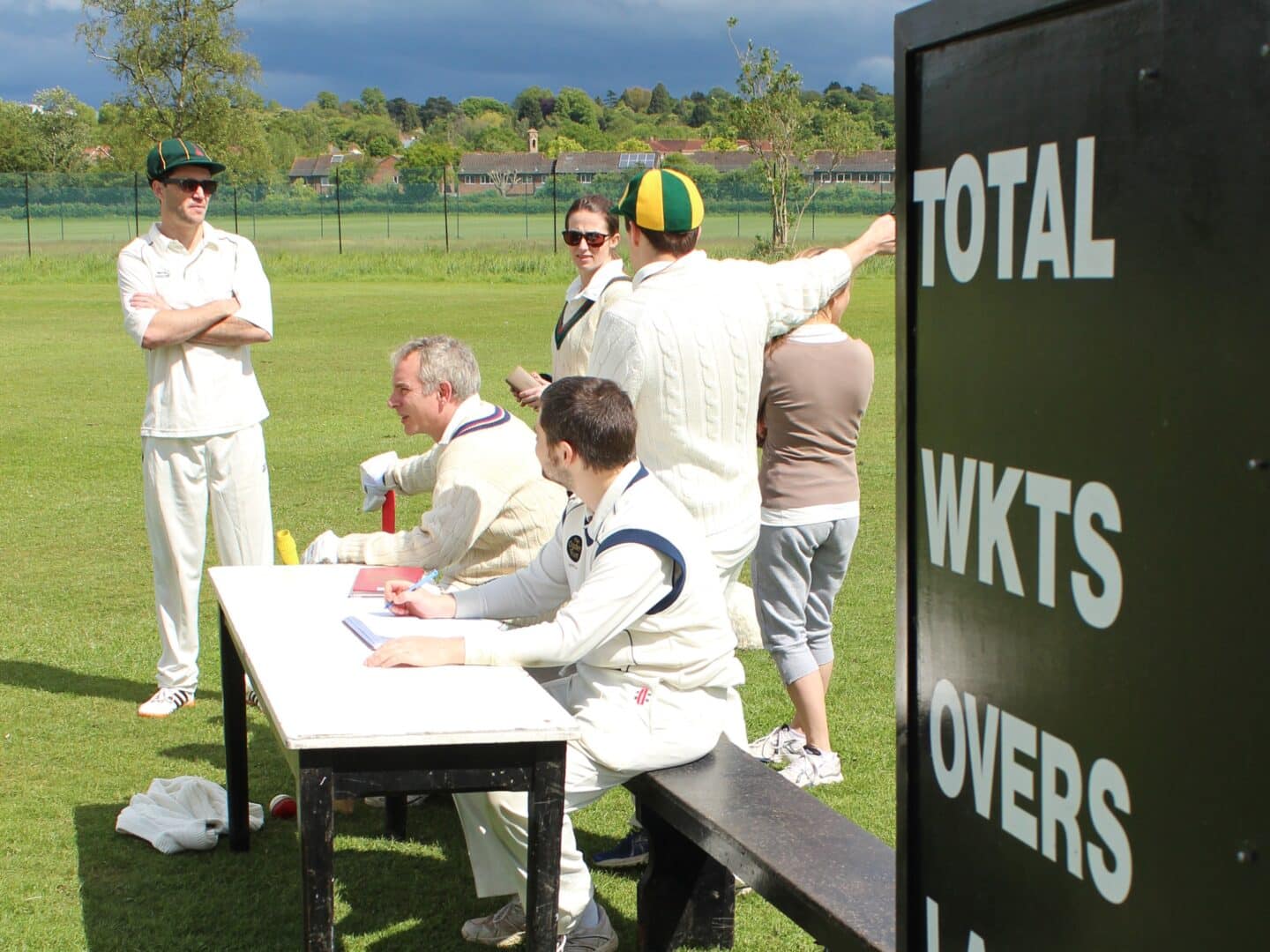 a group of cricket players standing near a table
