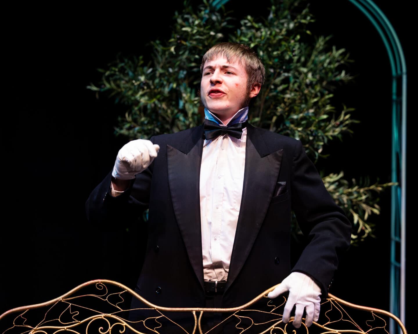 A student in black tie acting in a play