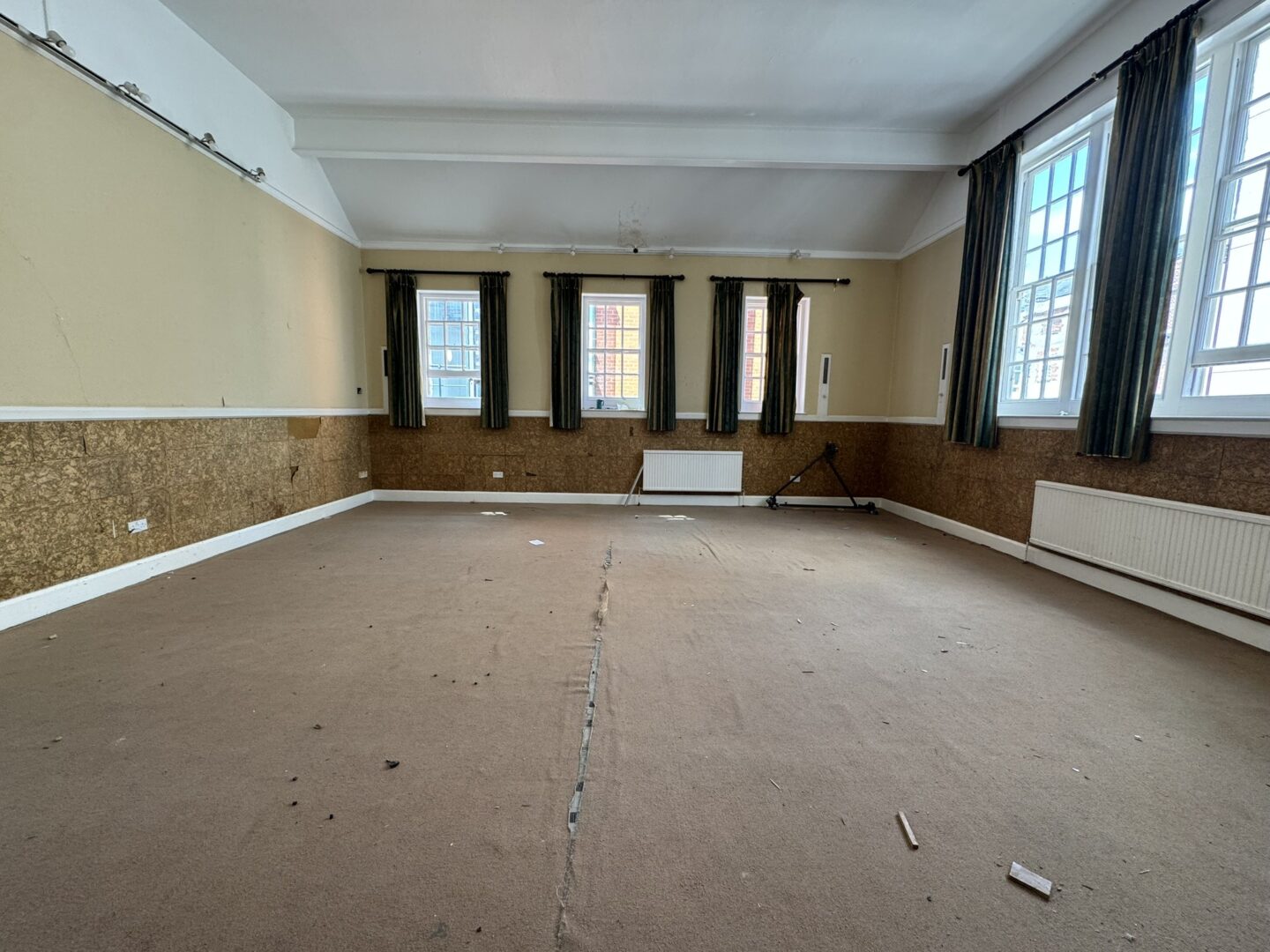 A dilapidated room with large windows