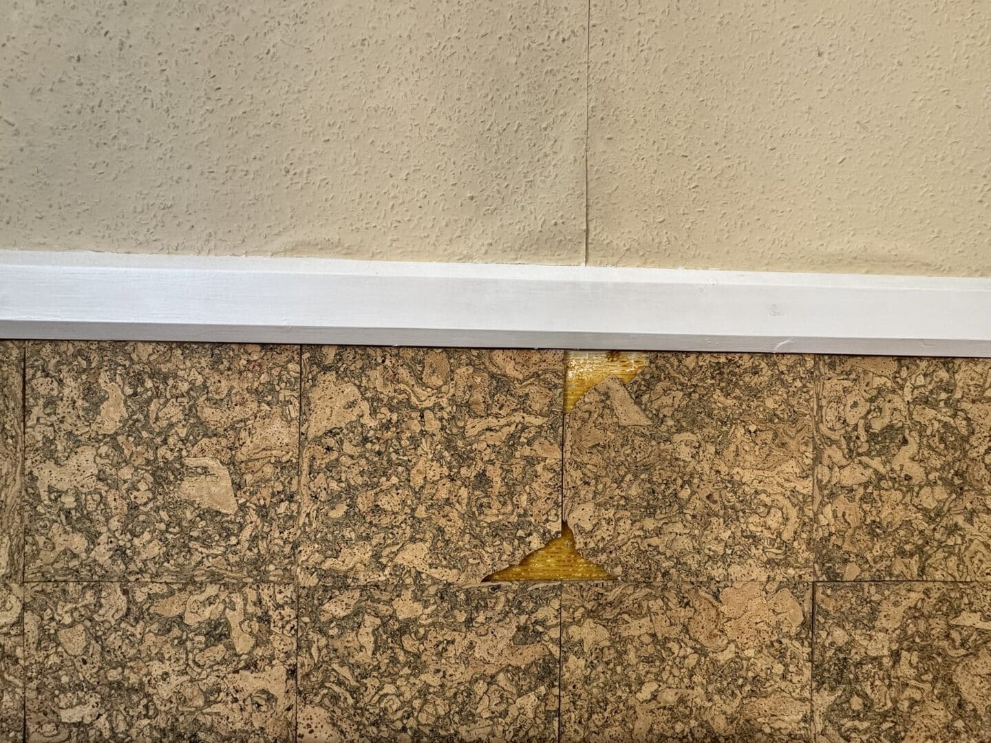 Closeup of broken wall panelling and peeling wallpaper