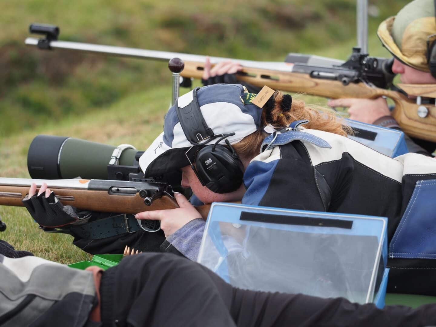 A young person aiming a rifle