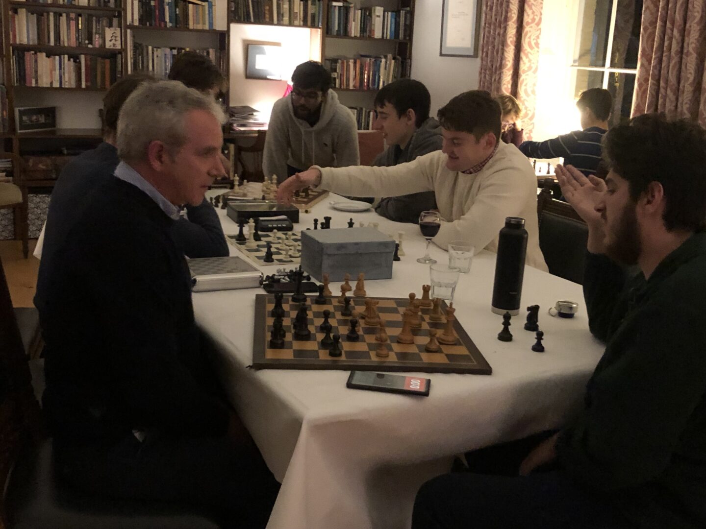 people sat a table playing chess.