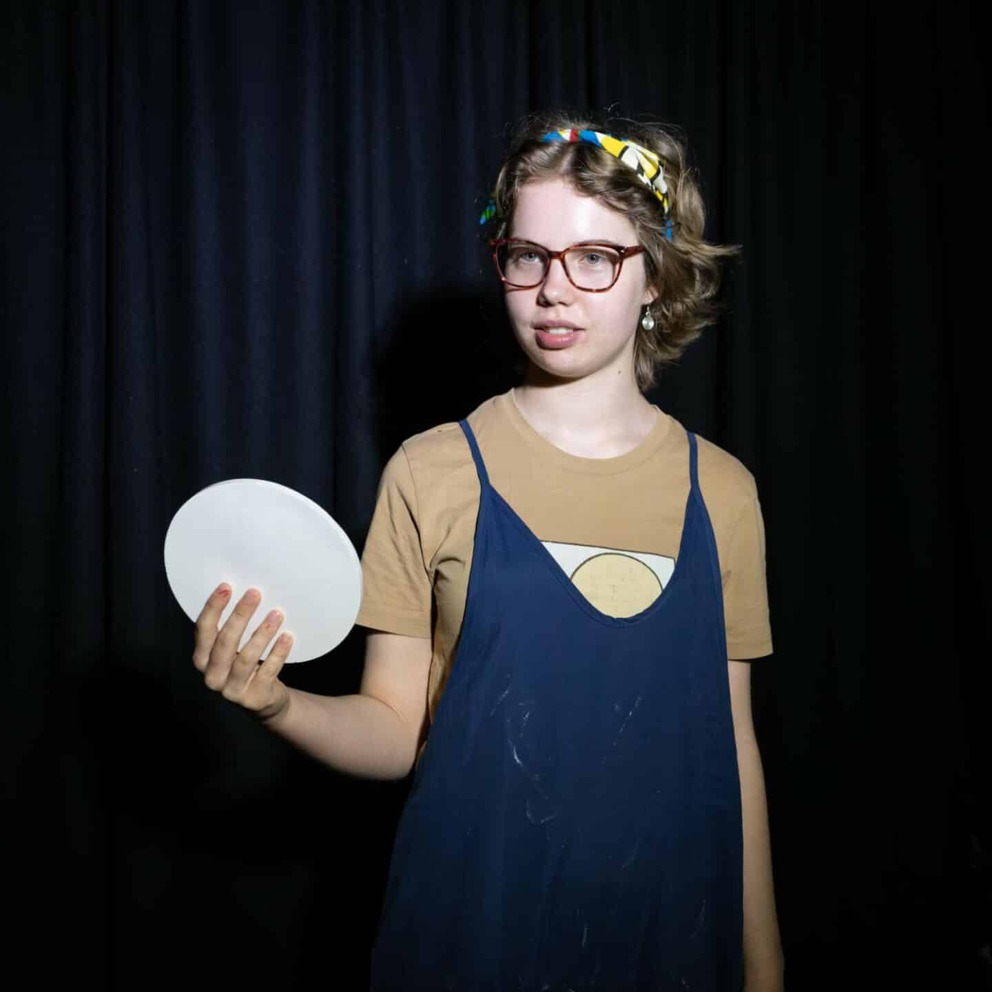 A young woman holding a white ceramic plate