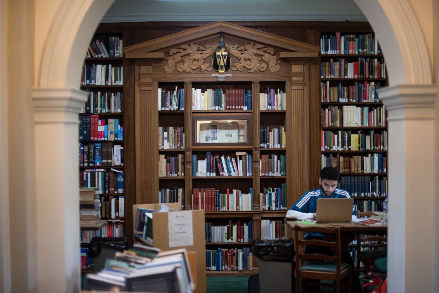 A student sitting at a table in a library