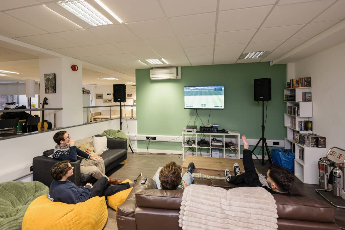 People sat on a sofa and bean bags playing a video game
