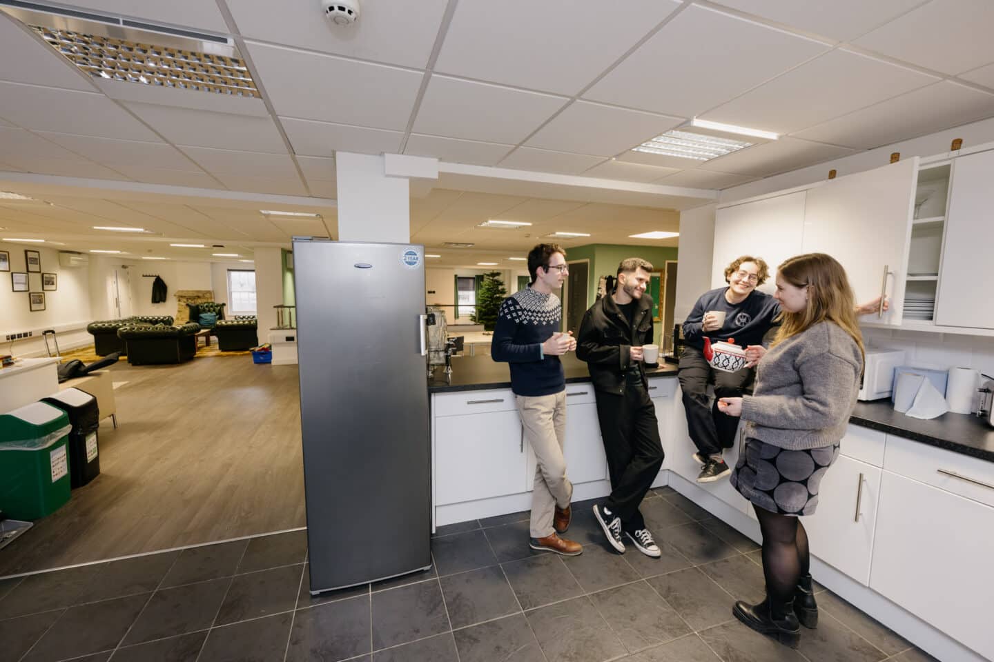 A group of people standing in a kitchen
