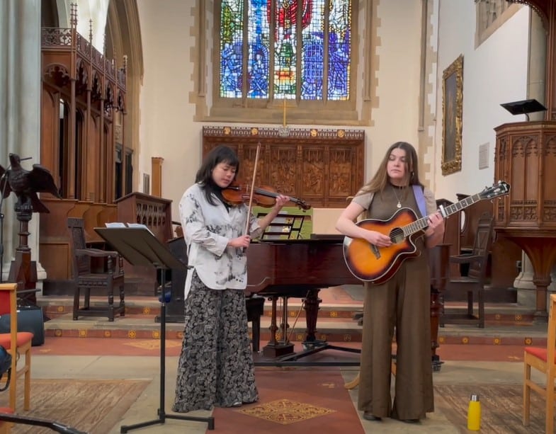 A violinist and guitarist performing in the St Peter's College Chapel