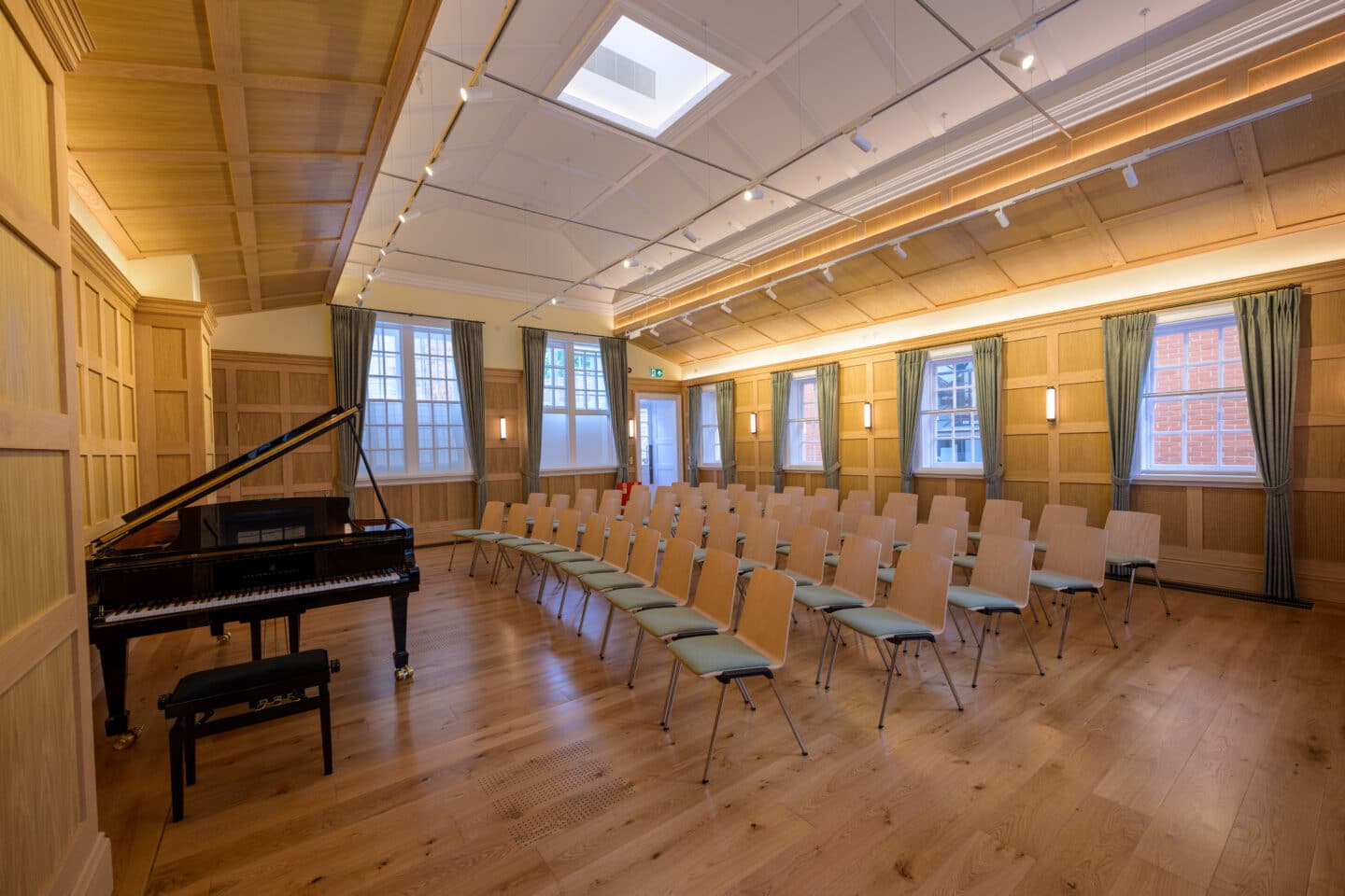 a wood-panelled room with several chairs and a piano
