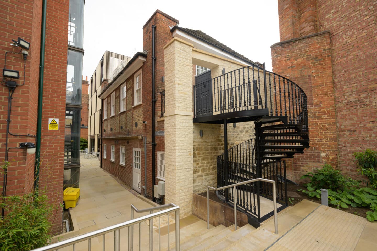 an old building with a new arts-and-crafts style spiral staircaise on the exterior.