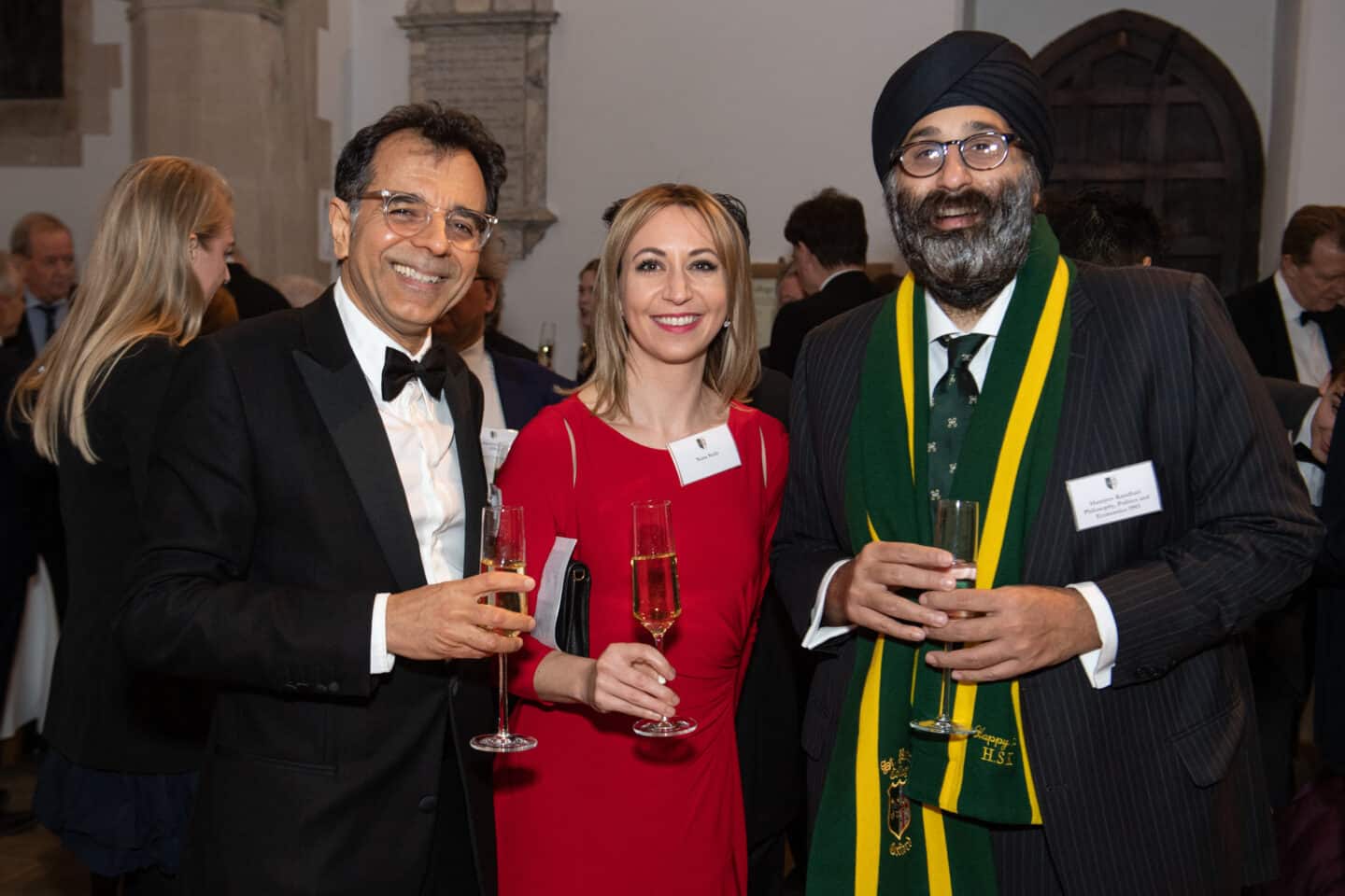 Three people smiling at a formal event