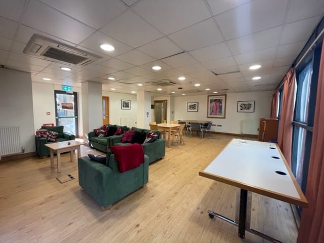 A common room with sofas and tables and chairs