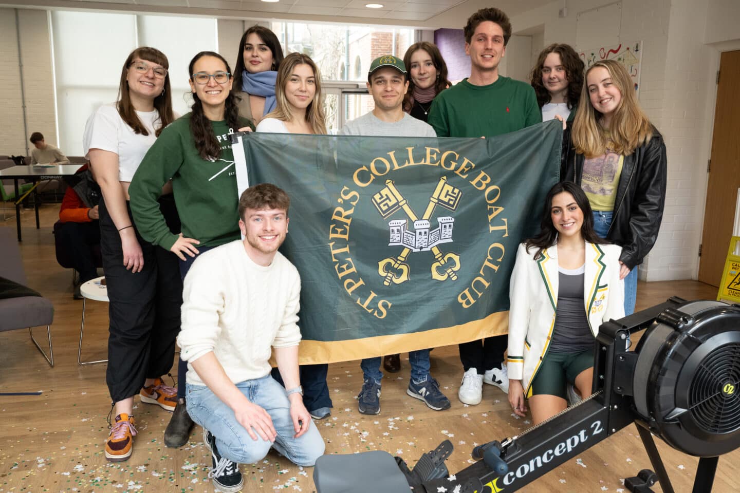 a group of students holding a flag with the St Peter's College logo