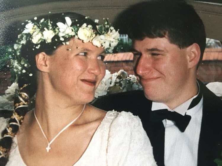 A man and woman in wedding attire smiling