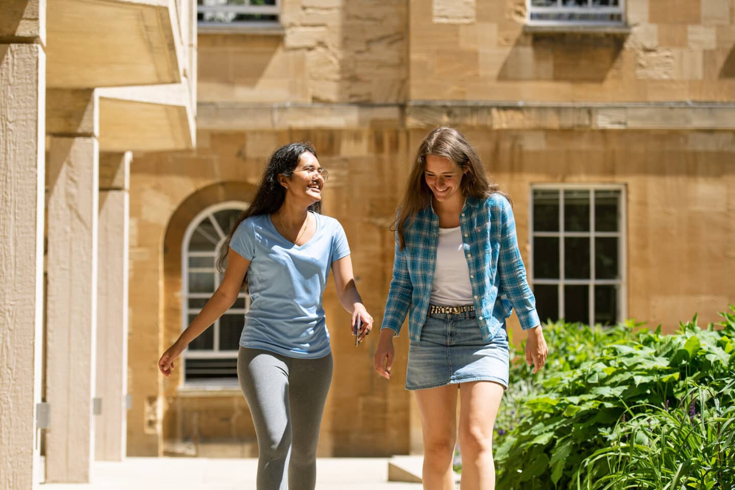 Two students smiling and walking outside