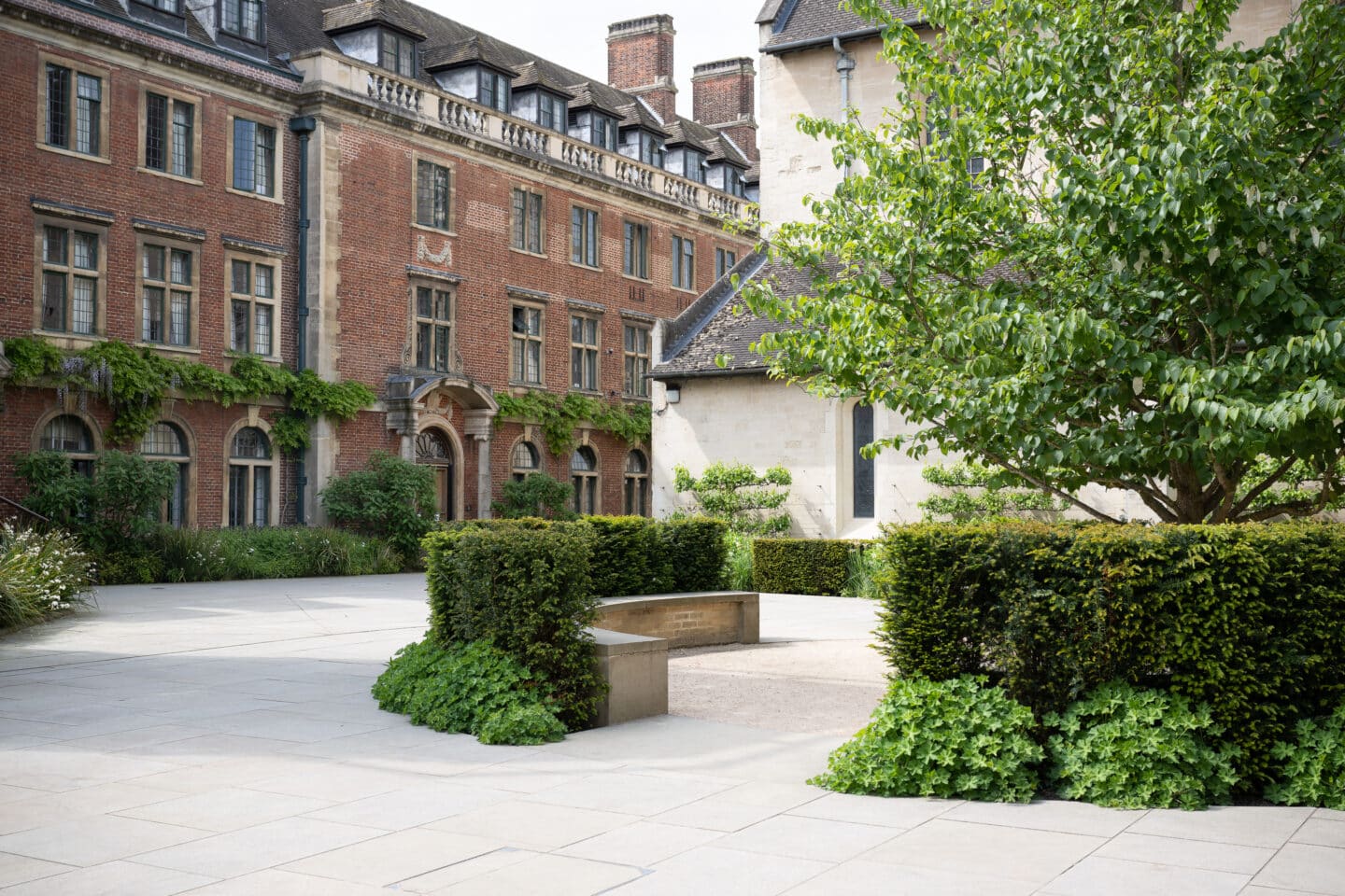 A stone-paved quad with a stone building and brick buildings