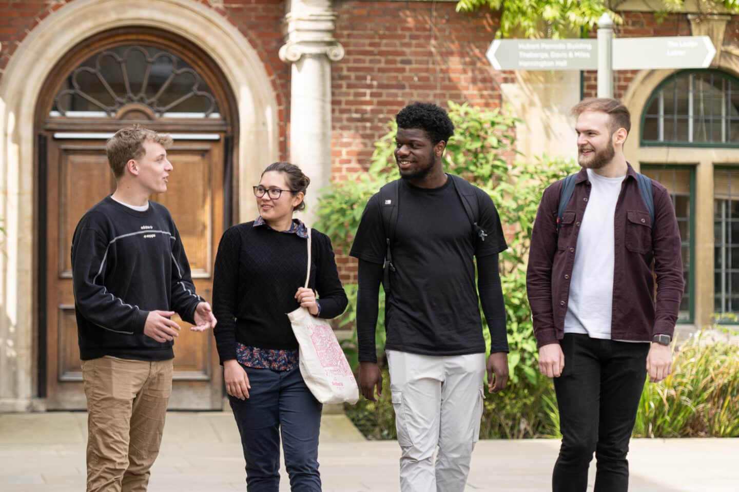 Four students walking in a quad