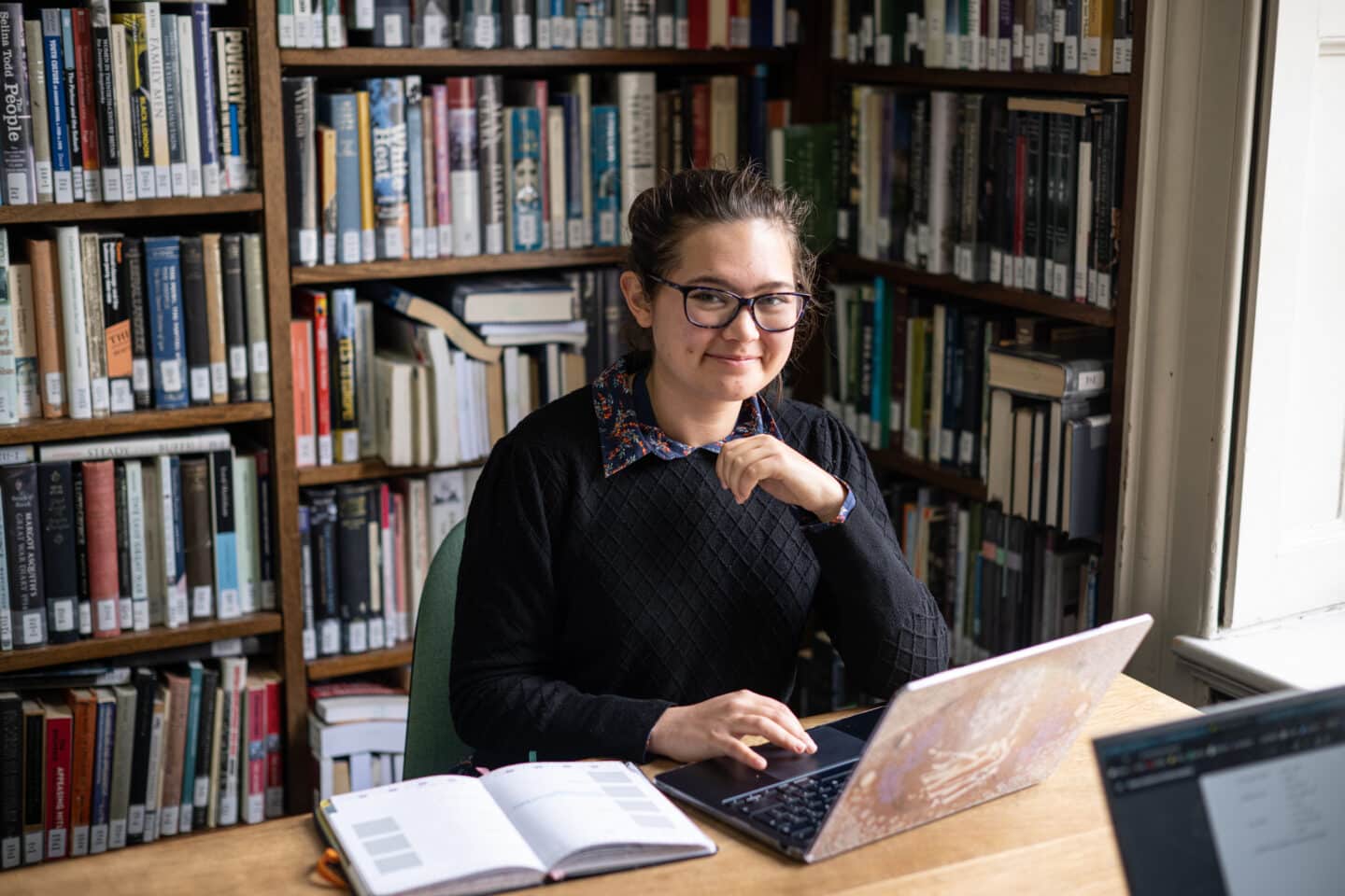 A student in a library with a computer