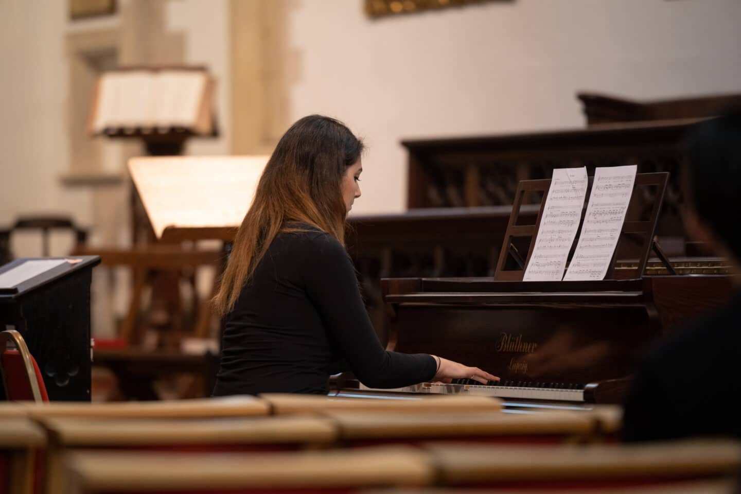 A woman playing a Bluthner piano