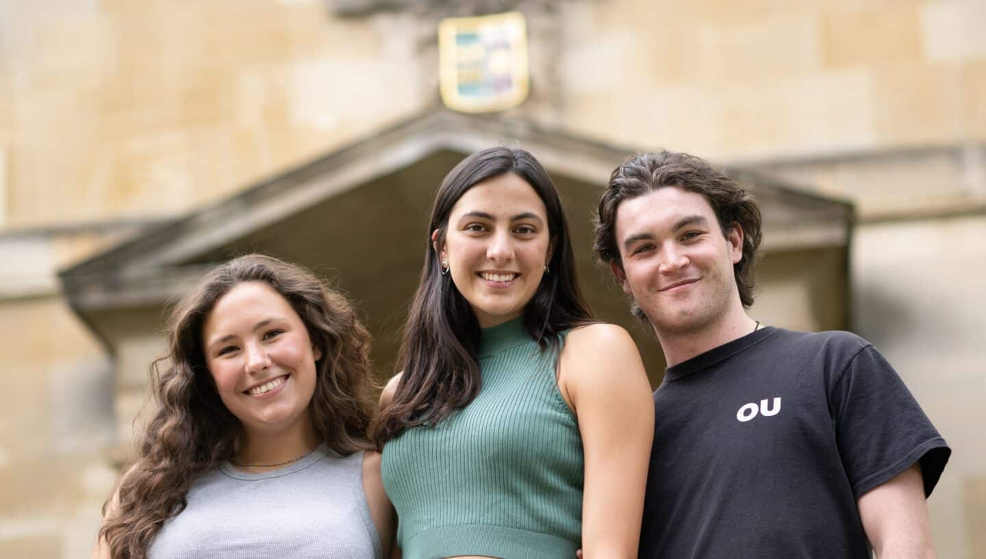 Three students standing together and smiling