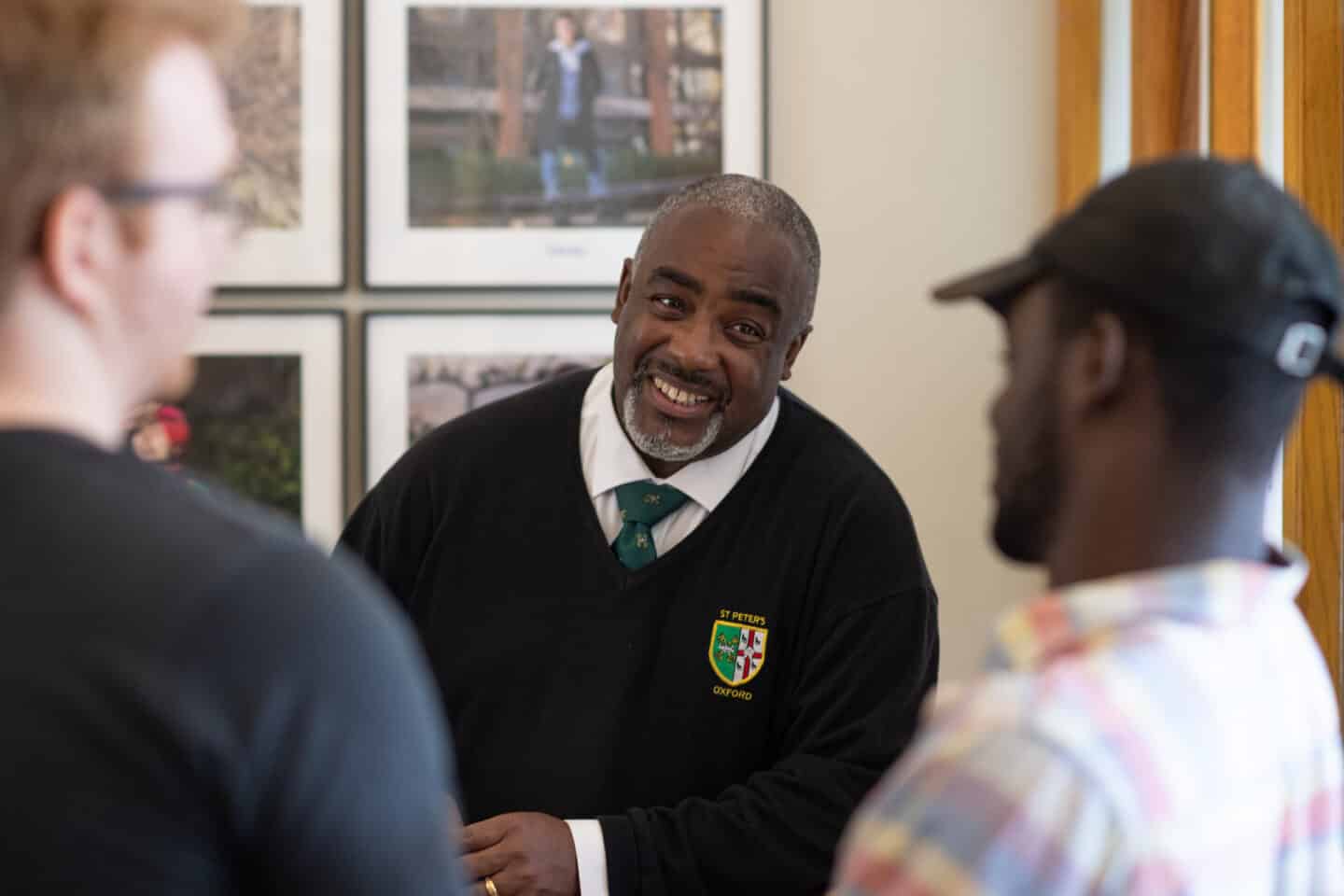 A porter speaking to two students