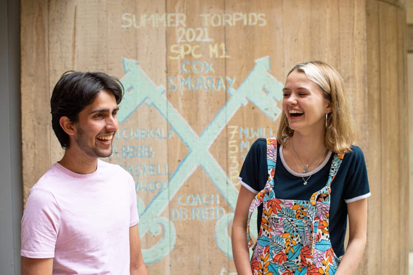 two students smiling and standing outside