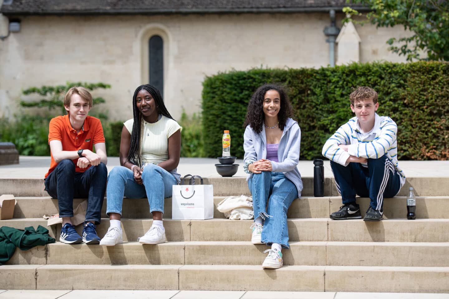 Four students sitting in the sunshine