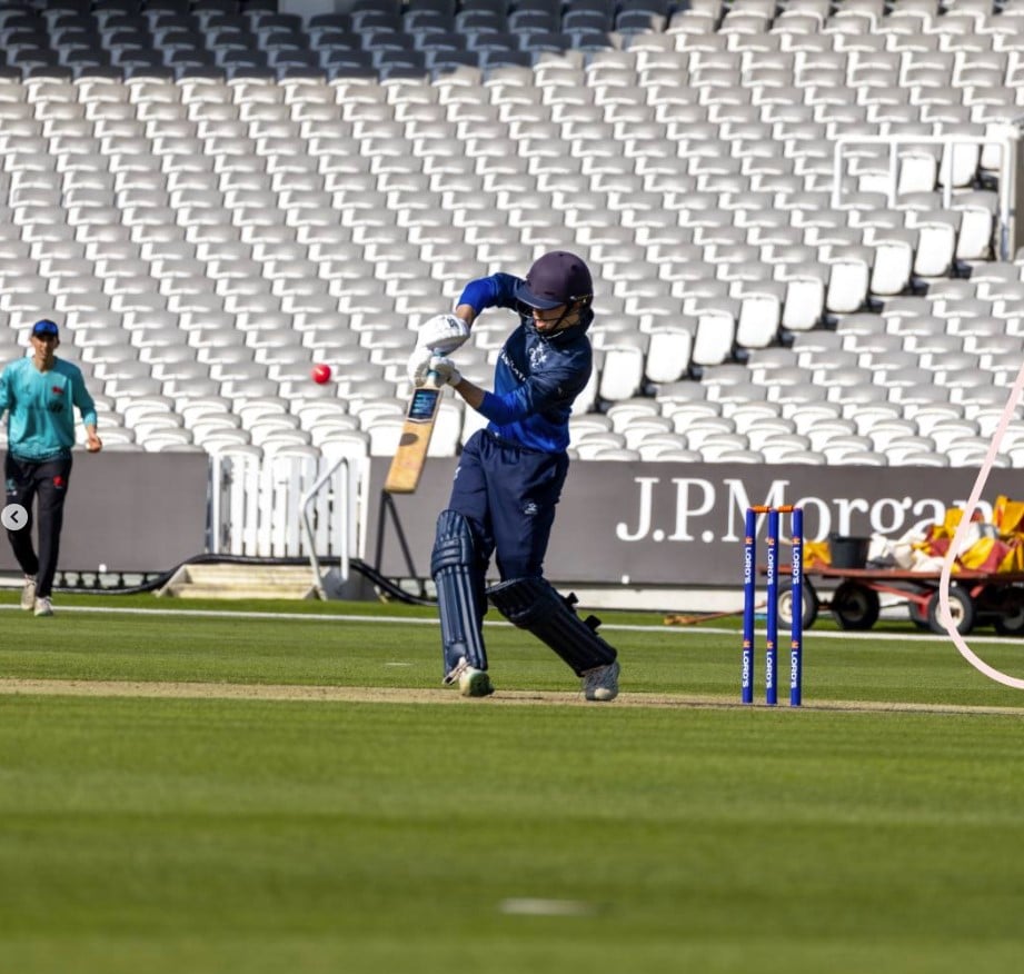 A young person batting at cricket