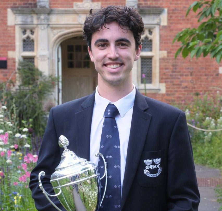 A young man holding a silver trophy