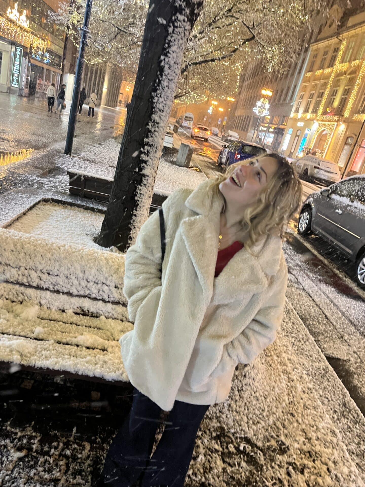 A student in a white coat standing in the snow.