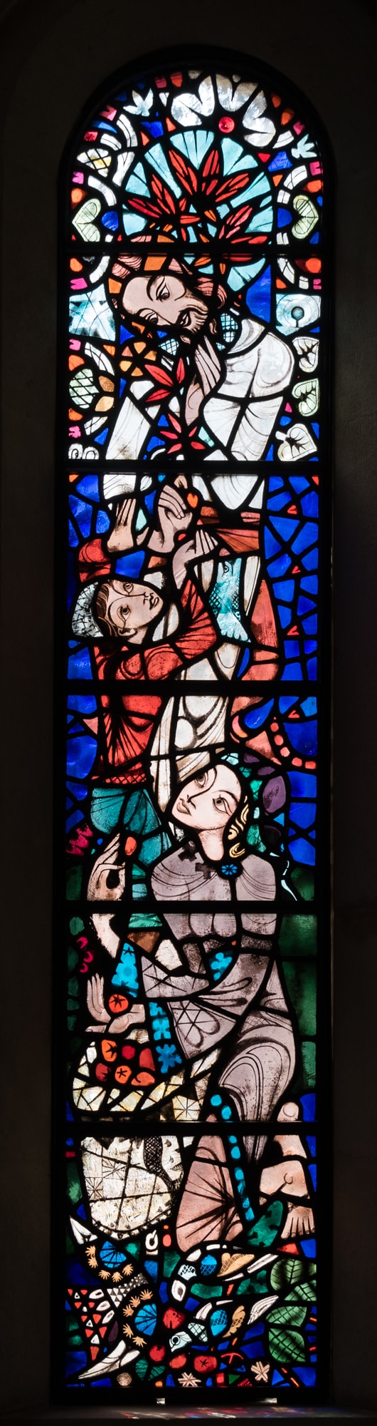 A stained-glass window with three human figures