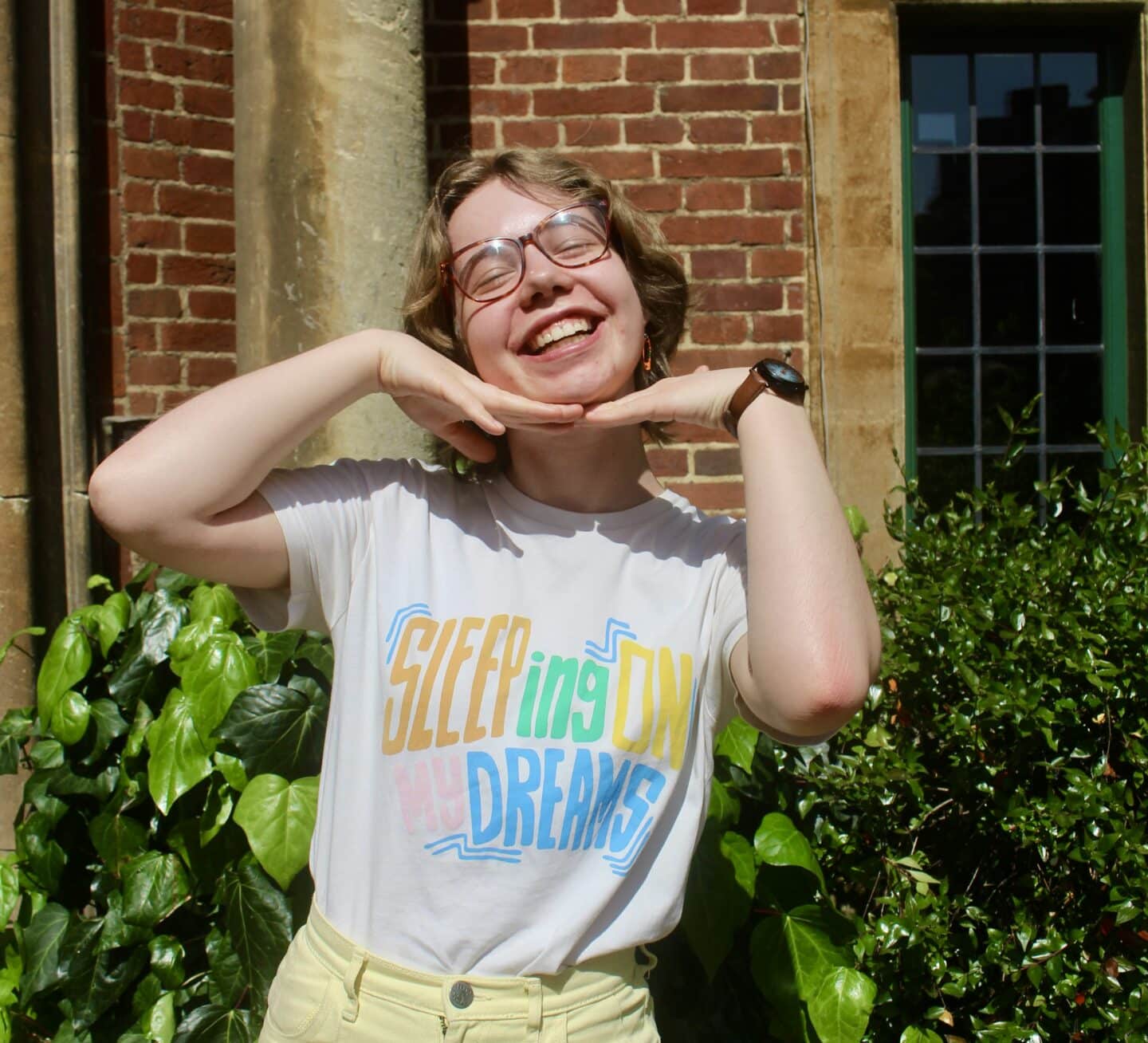 A smiling student with a t-shirt reading 'sleeping on my dreams'